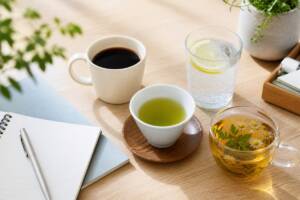 コーヒー、緑茶、炭酸水、ハーブティーを並べたデスク